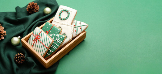 Box with beautiful Christmas cookies on green background with space for text