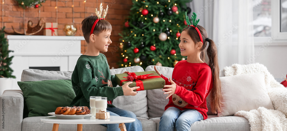 Wall mural little boy greeting his sister at home on christmas eve