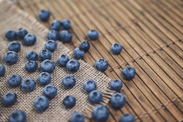 Summer background. Fresh blueberries on wooden background with burlap..