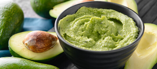 Bowl with delicious guacamole on table, closeup