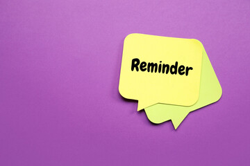 Sticky note with text REMINDER on violet background