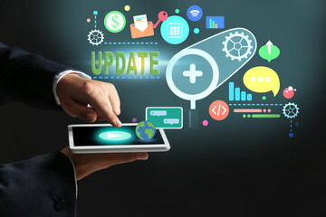 Hands of businesswoman with tablet PC on dark background. Concept of update