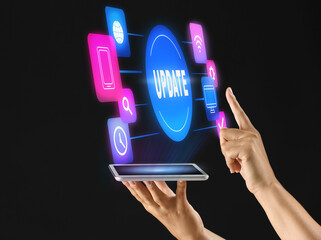 Hands of young woman with tablet PC on dark background. Concept of update