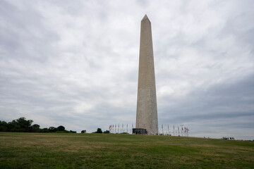 The Washington Monument, a 555-foot-tall obelisk-shaped building within the National Mall towering over Washington, DC, against a cloudy sky.