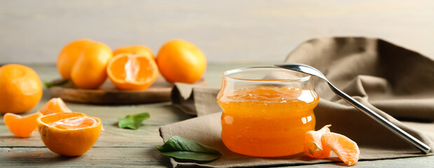 Jar of sweet tangerine jam on table
