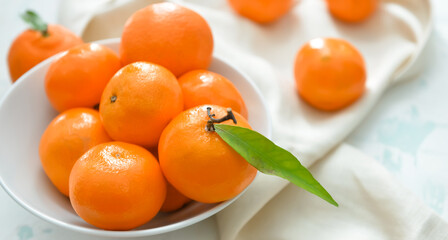 Bowl with sweet tangerines on table, closeup