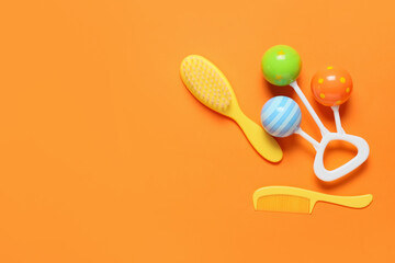 Hair brush, comb and rattle on color background