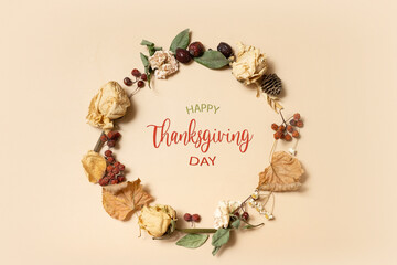 Autumn composition with Happy Thanksgiving Day greeting text. Wreath made of dried leaves and flowers on pastel beige background