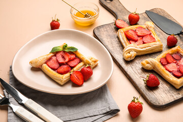 Plate with delicious strawberry puff pastry on beige table