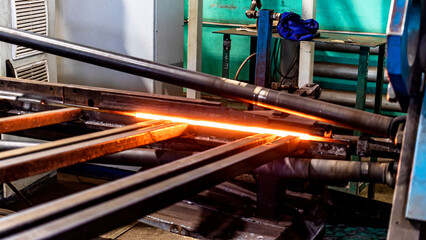 Machine for induction heating of metal. A metal rod heated in an induction furnace. Hot metal...