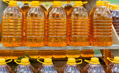 Row of bottles of fresh sunflower oil at a farmers' market. Sale of natural vegetable or palm oil,...