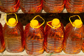 Row of bottles of fresh sunflower oil at a farmers' market. Sale of natural vegetable or palm oil,...