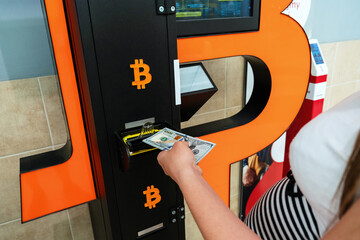 Atm bitcoin cryptocurrency machine. Woman withdraw american dollar bill cash. Usd hundred money...