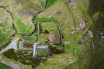 Small open sheep farm in Connemara, Ireland. Traditional stone walls and green fields. Agriculture industry. Wool production. Aerial view.