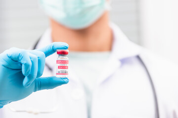 Obraz premium Young doctor or scientist in uniform wearing a face mask showing up coronavirus vaccine, nurse man holding bottle COVID-19 vaccination at laboratory, Healthcare And Medical concept