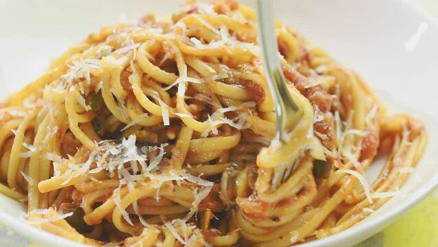 Eating pasta alla norma, served in a plate.
