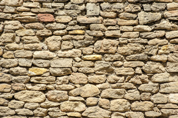 Ancient brick wall in Provence, France. Good for background, banner etc. Stones are irregular and with different light brown tones. Some stones have red and yellow tones.