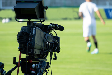 TV camera at the stadium, broadcasting during a football, soccer match