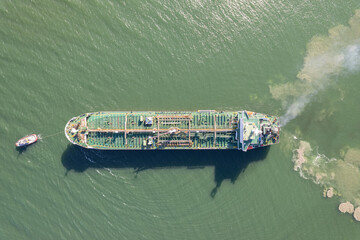 Top down view of Tug boat assisting big oil, chemical tanker. Large oil, chemical tanker ship...