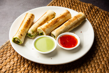 Indian paneer bread roll made using spiced grated cottage cheese mixed with spices & rolled & baked