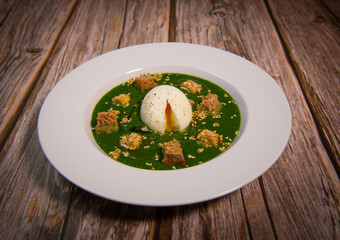 RECIPE FOR SOFT-BOILED EGG ON A COULIS OF TETRAGONE, BASIL, SAVORY AND PARSLEY SEASONED WITH CURCUMIN, SALT, ESPELETTE PEPPER, TOFU AND CROUTON TOASTED WITH SEZAME SEEDS. High quality photo