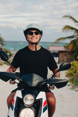 tourist rides a motorcycle with the beach and the sea in the background