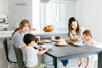 赤ちゃんにご飯を食べさせる女性（家）
