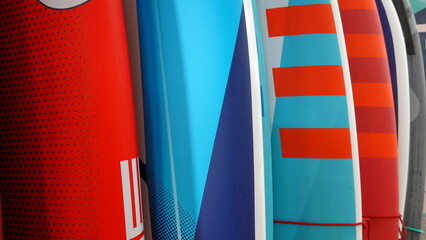 Multicolored surf boards different sizes and colors surfing boards on stand, surfboards rental...