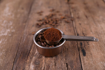Coffee beans and ground beans in measured form on a rustic background