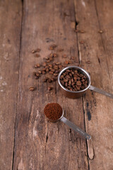 Coffee beans and ground beans in measured form on a rustic background