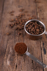 Coffee beans and ground beans in measured form on a rustic background