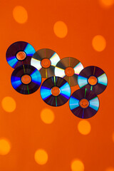 Large Variety of Arranged CD Disks or DVD Disks on Orange Background With Different Circular Dotted...