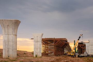Fototapeta premium Infrastructure construct concepts, Construction of Highway line in progress with heavy infrastructure, , Bridge construction site with crane lifting prefabricated concrete framework