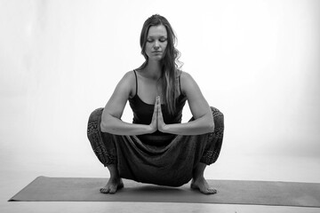 Sporty woman doing exercises on a rubber carpet in black and white