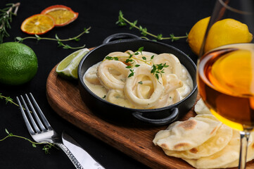 squid rings in a pan with a sprig of thyme
