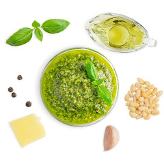 Top view of glass bowl with italian herb pesto sauce made of blended basil leaf, olive oil, black pepper, parmesan cheese, pine nuts and garlic isolated on white background used for salad dressing