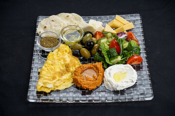 oriental breakfast with hummus and salad on a black background
