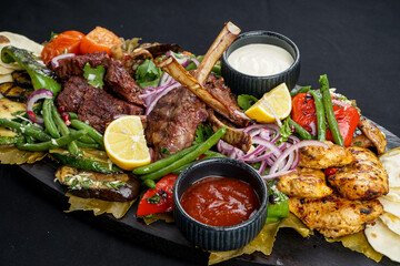 fried meat dish loin on the bone kebab and vegetables grilled with ketchup on the board macro photo
