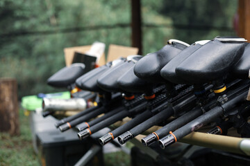 Paintball equipment. A row of paintball shotguns. Tool for conducting tactical battles.