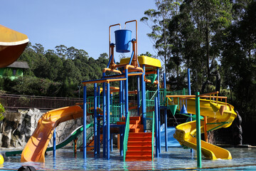 Water park, bright multi-colored slides with a pool. A water park without people on a summer day.