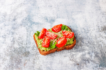Obraz na płótnie Canvas Avocado toasts with cherry tomatoes and raddish slices,sesame seeds.