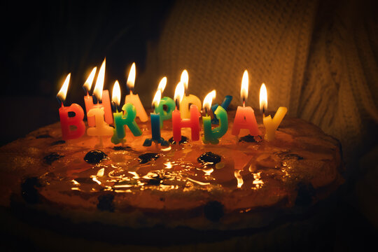 Multi-colored candles in the form of letters on a birthday cake