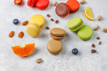 Colorful french dessert macarons with fresh fruits and nuts.