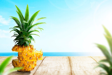Obraz premium Slice of fresh pineapple on wooden table with ocean view
