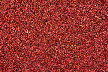 Ground sumac spice powder background.