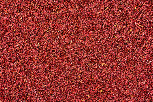 Ground sumac spice powder background.