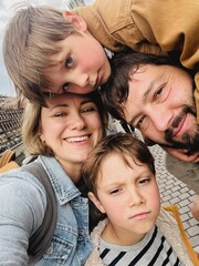 Caucasian family taking selfie photo in the city