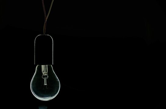 turned off incandescent light bulb on a black background