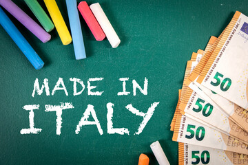 Fototapeta na wymiar Made in Italy. Euro money and pieces of chalk on a green board