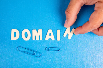 Domain. Text from white wooden letters on a blue background